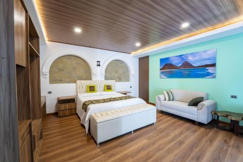 a bedroom with a bed and a couch at Hotel Boutique La Torre in Tupiza