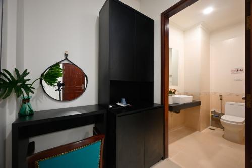 a bathroom with a mirror and a sink and a toilet at Hotel Trung Mai-Sân Bay in Ho Chi Minh City