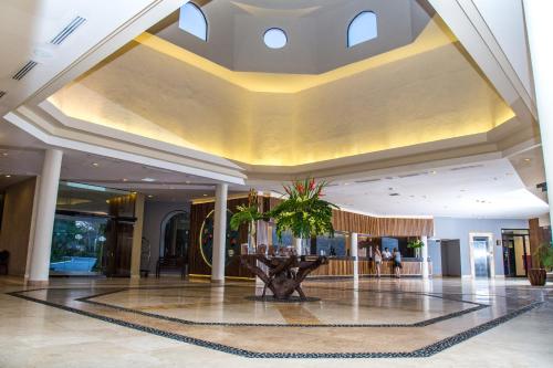 a lobby with a large ceiling with a plant in the middle at Dreams Playa Bonita All Inclusive in Playa Bonita Village