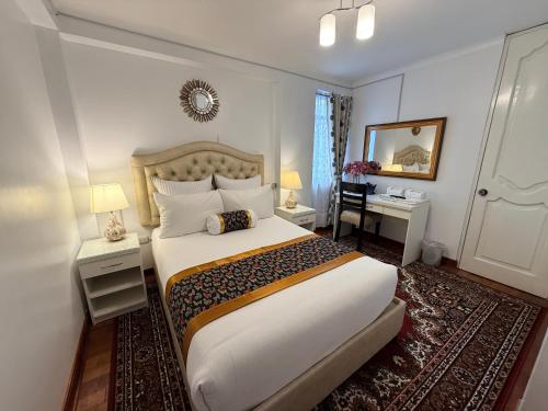 a bedroom with a large bed and a mirror at Hotel-Apartment INKASABIOS in Cusco