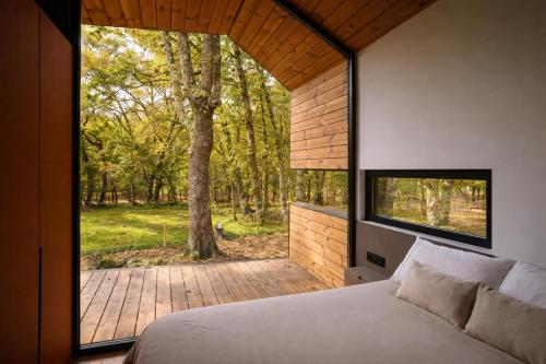 a bedroom with a bed and a large window at Cabañas en Ribeira Sacra, Borbela de Luz in Villar de Ordelles