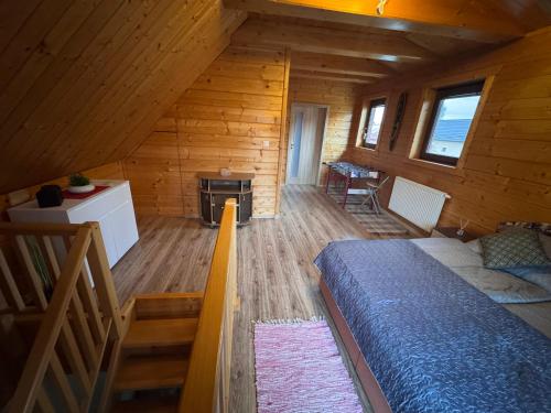 a room with a bed and a fireplace in a log cabin at Chalupa u Jožka in Betlanovce