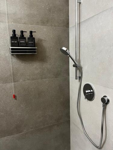 a shower with three bottles on a shelf in a bathroom at Valle degli Ulivi appartamento in Terni