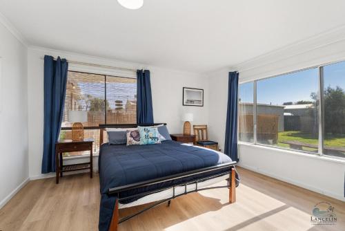a bedroom with a bed and a large window at Ocean Spray in Lancelin