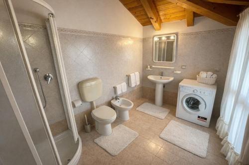 a bathroom with a toilet sink and a washing machine at Residence Mediterraneo - Agenzia Cocal in Caorle