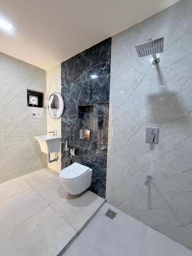 a bathroom with a toilet and a sink and a shower at LAGUNA BLU beach villa in Irimbranallūr