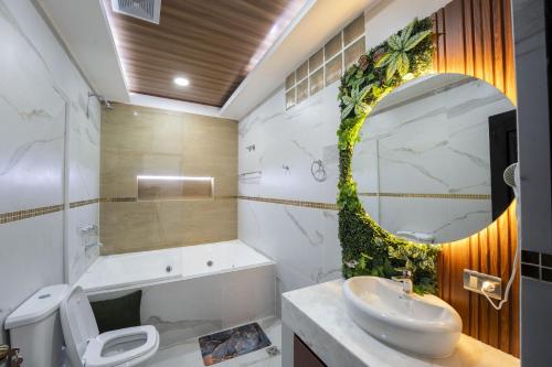 a bathroom with a sink and a toilet and a mirror at Hotel Boutique La Torre in Tupiza