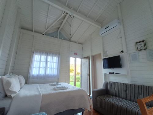 a bedroom with a bed and a couch in a room at Pousada Landhaus in Urubici