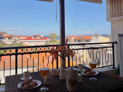 a table with food and drinks on a balcony at VASILICA Apartments in Ierissos