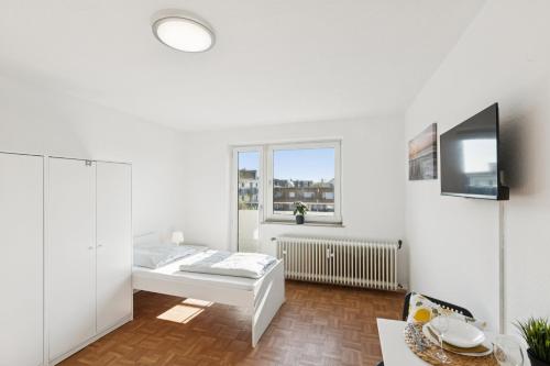a white room with a bed and a window at Apartment mit Balkon in Lünen in Lünen