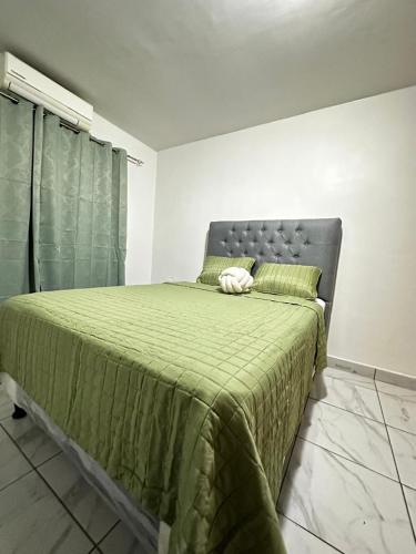 a bedroom with a bed with a green blanket at Casa Privé, Comayagua in Comayagua