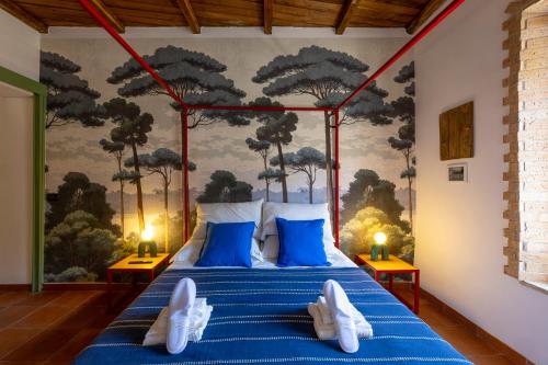a bedroom with a blue bed with a painting on the wall at Luce sul Duomo in Tivoli