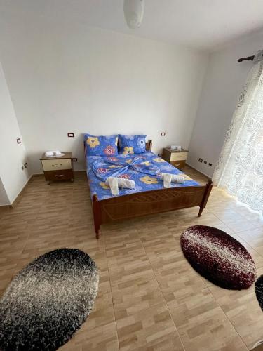 a bedroom with a bed and two rugs at Vila Du Lac Blue in Lin