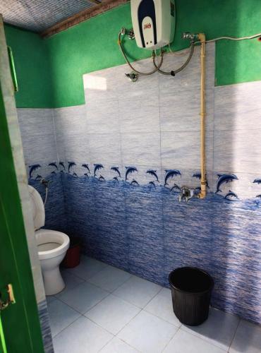 a bathroom with a toilet and a shower with blue tiles at Green Haven in Kalimpong