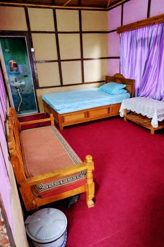 two beds in a room with a red carpet at Green Haven in Kalimpong