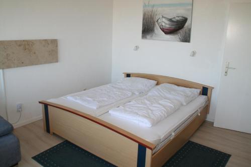 a bed in a room with a painting on the wall at FW Knütel Nr 59 in Burgtiefe auf Fehmarn 