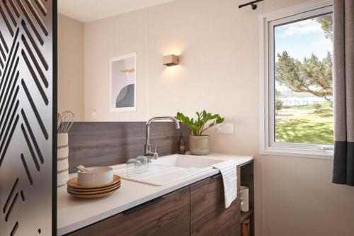 a kitchen with a sink and a window at Le Maquis Plage Corse in Poggio-Mezzana