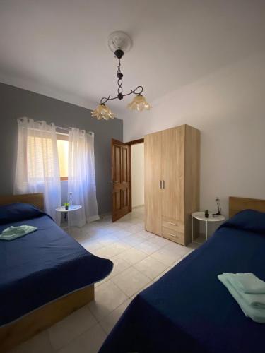 a bedroom with two beds and a small cabinet at St Julians Mansion Rooms in St. Julianʼs