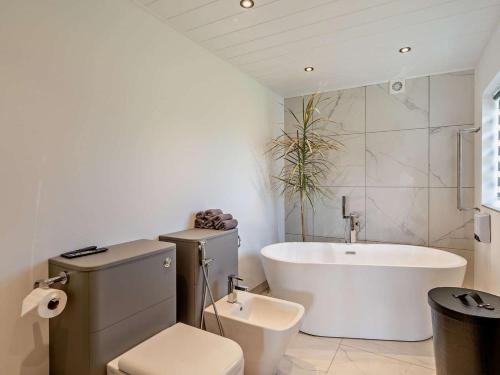 a bathroom with a tub and a toilet and a sink at 3 Bed in Carlisle oc-94673 in Longtown
