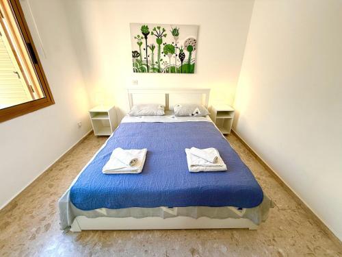 a bedroom with a blue bed with towels on it at Latchi Premium View in Lachi