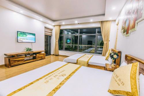 a bedroom with two beds and a flat screen tv at FLC Grand Villa BT31-23 in Sầm Sơn
