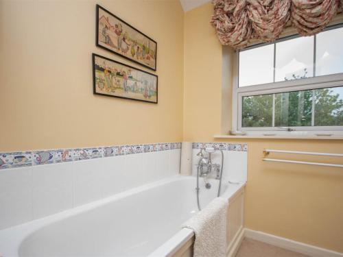 a bathroom with a tub and a window at 4 Bed in Bridport oc-dc195 in Loders