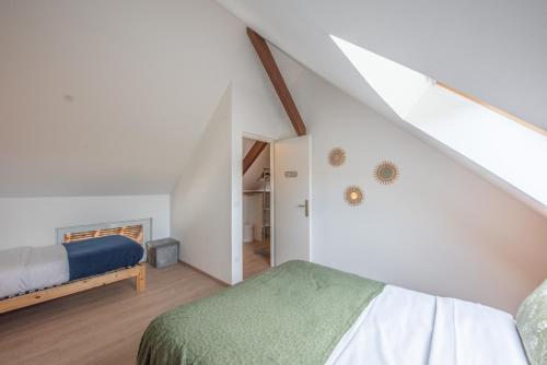 a attic bedroom with a bed and a staircase at Le Carre Saint Pierre - Chambres d'hôtes in Marey-lès-Fussey