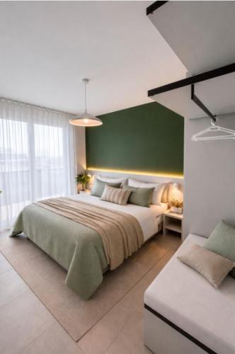 a bedroom with a large bed and a green wall at Woody Green Charming Apartments - Agenzia Cocal in Caorle