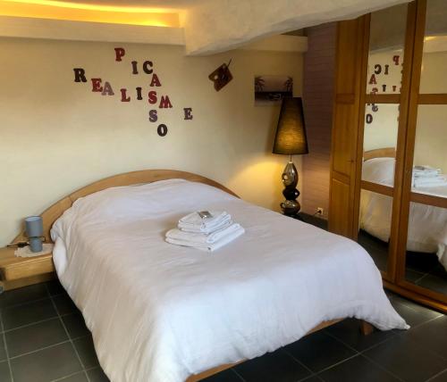 a bedroom with a bed with towels on it at Le Chant des Elfes in Samer