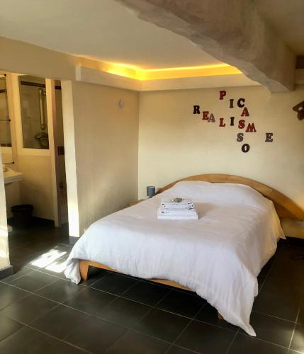 a bedroom with a white bed with a sign on the wall at Le Chant des Elfes in Samer