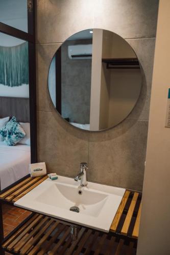 a bathroom with a sink and a mirror at Hotel Macaw Cúcuta in Cúcuta