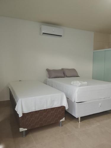 two beds sitting next to each other in a room at Cantinho do sol in Maceió