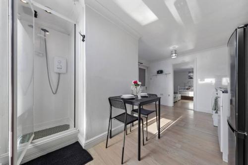 a dining room with a table and a kitchen at Private Annex with Gated Driveway near Grove Park Station in Hither Green