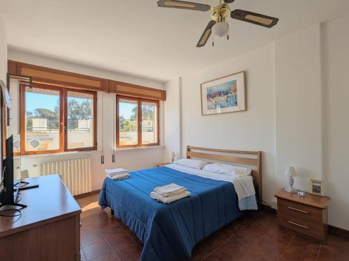 a bedroom with a blue bed and a ceiling fan at Domus Caelestia in Anzio