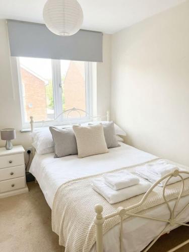 a white bedroom with a bed and a window at 2 Private Rooms in Shared Apartment with Kitchen in Leeds