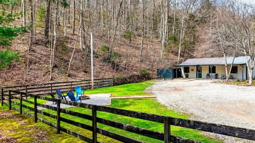 a house with a fence next to a yard at Brookside Cabin in South Bloomingville