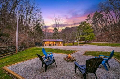 a group of chairs sitting around a fire in a yard at Brookside Cabin in South Bloomingville