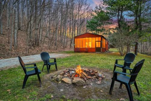 three chairs sitting around a fire in a yard at Creekside Hideaway in Laurelville