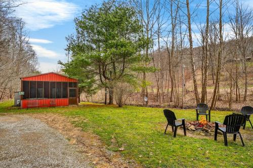 a group of chairs sitting around a fire in a field at Creekside Hideaway in Laurelville