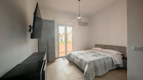 a bedroom with a bed and a large window at Ischera Apartments in Guspini