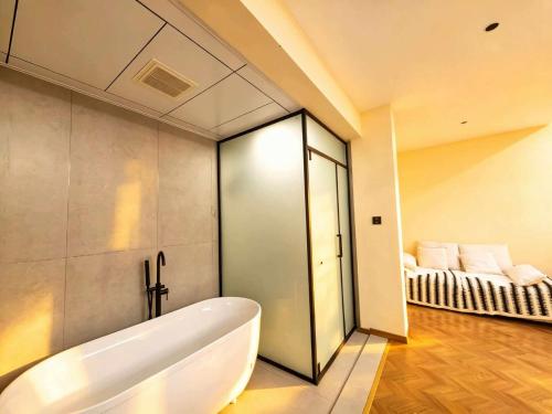 a bathroom with a tub and a couch in a room at NAIYI Forest Park Resort in Zhangjiajie