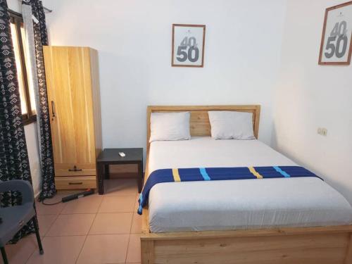 a bedroom with a bed and a nightstand and a bed sidx sidx at Guest House HEBERTOGO in Lomé