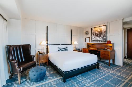 a bedroom with a bed and a desk and a chair at The Charles Hotel in Harvard Square in Cambridge