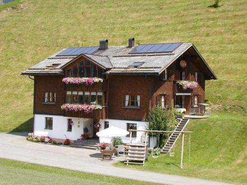 a house with solar panels on top of it at Appartments Haus Monika in Schoppernau