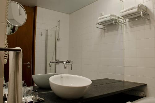 a bathroom with a sink and a bath tub at VIP Executive Arts Hotel in Lisbon