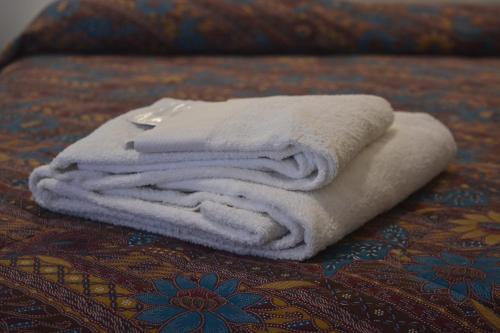 a pile of towels sitting on top of a bed at Home Sweet Home in Rome