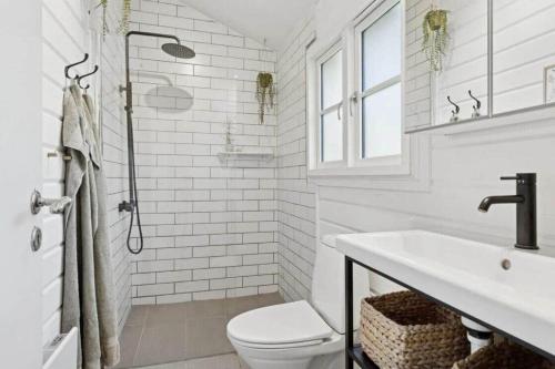 a white bathroom with a toilet and a sink at TV1721-Jerup-Engsigen-12 in Bratten Strand