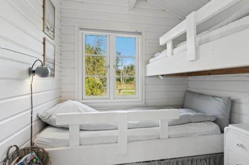 a white room with a bunk bed and a window at TV1721-Jerup-Engsigen-12 in Bratten Strand