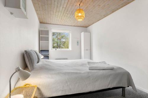 a bedroom with a white bed with a ceiling at TV1718-Bindslev-Astersvej-4 in Tversted