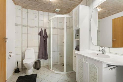 a bathroom with a toilet and a sink and a mirror at TV1718-Bindslev-Astersvej-4 in Tversted